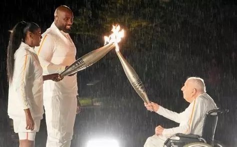 Charles Coste transmet la flamme olympique à Marie-José Pérec et Teddy Riner lors de la cérémonie d'ouverture des JO de Paris 2024.jpg